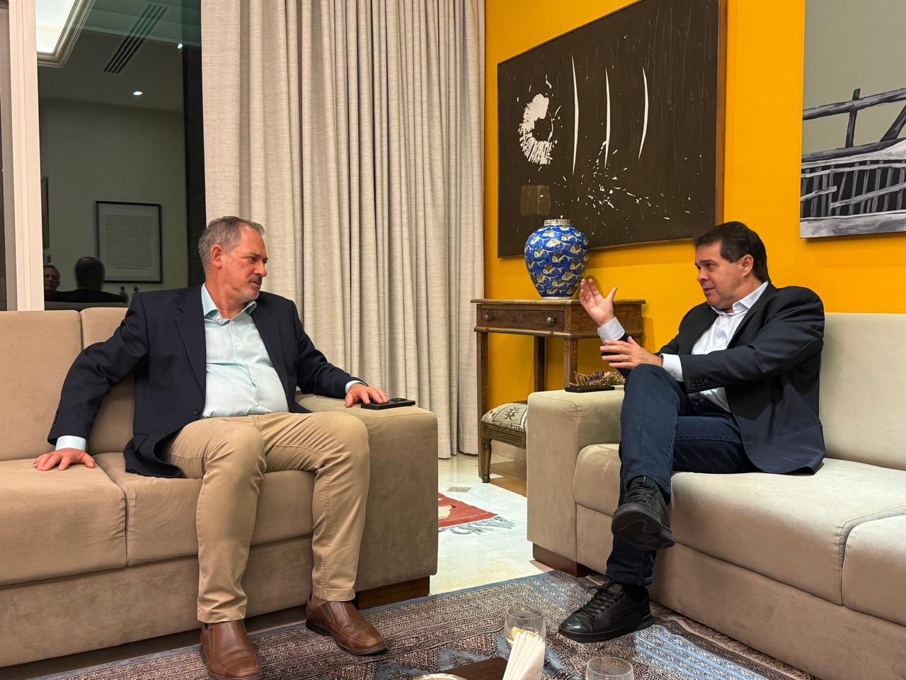 Evandro e o embaixador conversm sentados em sofás